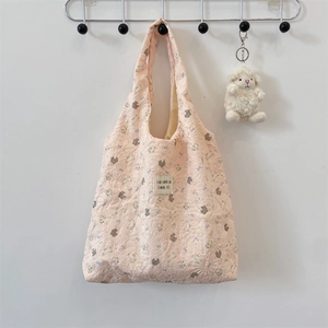Detail of pink quilted tote bag showing rabbit print and sozakka beauté woven label