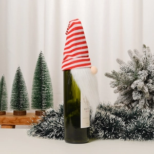 Détail du cache-bouteille de Noël gnome avec bonnet tricoté à rayures rouges et barbe