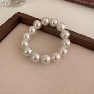 Detail of elegant white round pearls on a vintage french style elastic bracelet