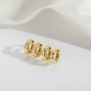 Minimalist gold hoop earrings with sparkling zircon stones in a modern C-shaped design