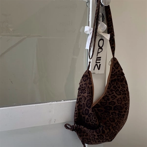Macro detail of leopard print crescent bag with plush suede texture and metal zipper