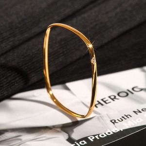 Detail of square gold titanium steel bracelet featuring a single cubic zirconia stone