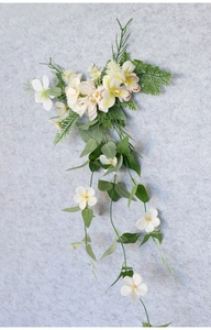 Detailed macro view of white orchid and lily artificial floral wall hanging with green vines