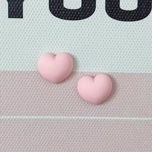 Détail macro de breloques en résine cœur rose mat pour bijoux DIY et nail art