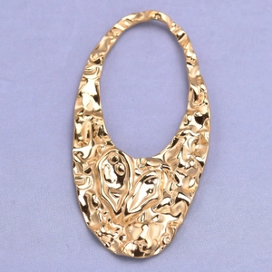 Close-up of golden irregular oval 304 stainless steel pendant with hammered texture detail