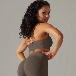 Close-up of seamless ribbed brown yoga sports bra and leggings set with textured fabric