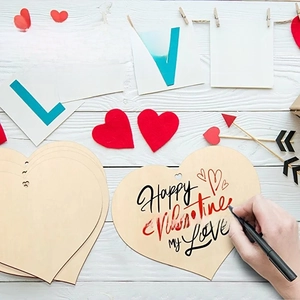 Macro view of DIY heart-shaped wooden tags with handwritten Happy Valentine greeting