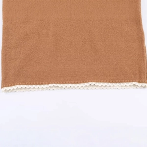 Pull en maille caramel avec détails de bordure en dentelle blanche sur fond blanc