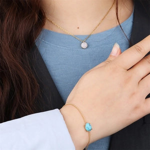 Professional model wearing 18k gold link chain necklace and bracelet with natural gemstones