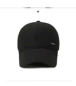 Detailed view of black wool baseball cap with silver metal leaf logo and knit texture