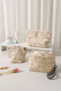 Three-piece beige canvas cosmetic bag set with tassels and stylish woven handle details