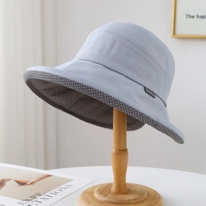 Détail du chapeau de soleil bleu clair avec doublure à carreaux gris sur support