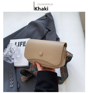 Detail of khaki leather crossbody bag with ethnic style wide shoulder strap