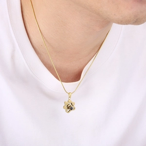 Détail du collier de projection patte dorée porté par un mannequin sur un t-shirt