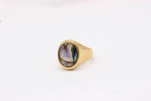 Macro shot of gold oval signet ring featuring a polished iridescent shell inlay