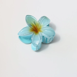 Close-up of sky blue gradient plumeria hair claw clip with glossy resin finish
