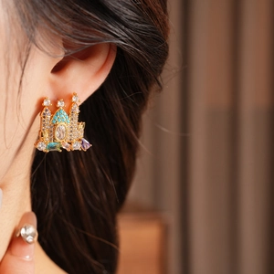 Detail shot of gold-plated castle earrings with colorful zircon stones on model