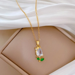 Macro detail of tulip pendant necklace with clear zircon and green crystals in jewelry box