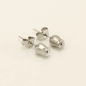 Macro detail of polished silver tulip bud stud earrings with butterfly backings
