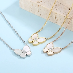 Detailed view of silver, gold, and rose gold butterfly necklaces with white shells