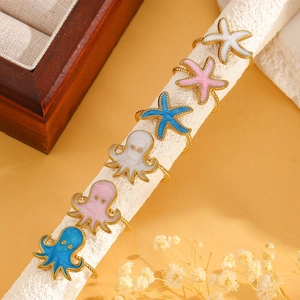 Detailed macro view of starfish and octopus gold rings with colorful enamel finish
