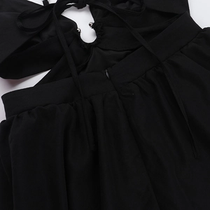 Détail du dos de robe noire avec laçage, fermeture éclair invisible et plis élégants