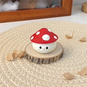 Macro shot of hand-carved mushroom desk ornament with a cute smiley face on wood base
