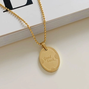 Minimalist gold oval 'Good Luck' pendant necklace on a delicate bead chain