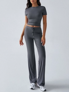 Full view of women's dark gray short sleeve crop top and drawstring flare pants set
