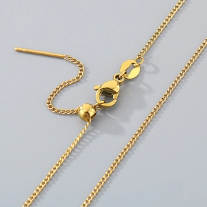 Macro detail of gold adjustable slider bead and lobster clasp on fine metal necklace