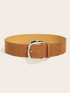 Detail of wide brown suede waist belt featuring a large polished silver oval buckle