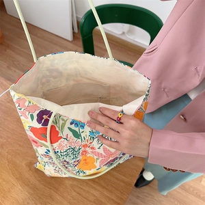 Vue intérieure du sac cabas floral montrant sa grande capacité et sa poche zippée