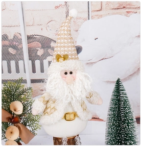 Détail du Père Noël en peluche avec bonnet doré scintillant et barbe douce festive