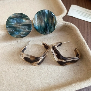 Gros plan détaillé de boucles d'oreilles en acrylique marbré et écaille de tortue