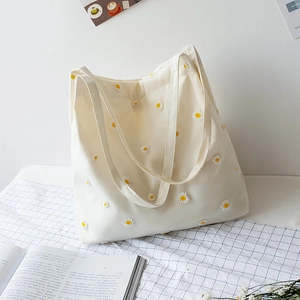 Chic cream canvas tote bag featuring intricate yellow daisy embroidery for women