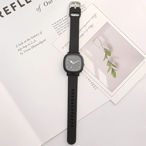 Detail of square black dial watch with white Arabic numerals on silicone strap