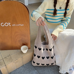 Detail of knitted heart pattern tote bag with wide handle for casual daily use