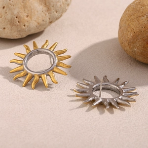 18K gold and silver hollow sun-shaped stainless steel stud earrings on natural rock