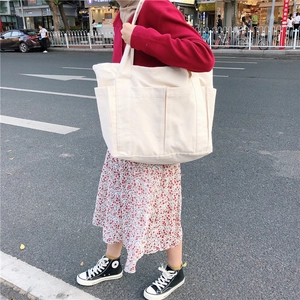 Minimalist cream canvas tote bag with outer pockets for daily commuting and shopping