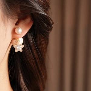 Detailed view of 18K gold plated earring with star pendant and textured pearl bead