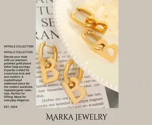 Detailed view of two pairs of gold-plated letter B earrings on a white decorative plate