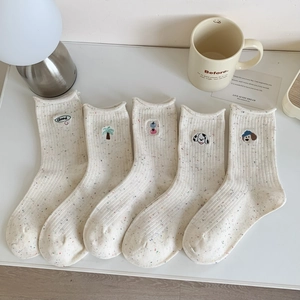 Vue détaillée de cinq chaussettes en coton crème avec broderies de chiots mignons