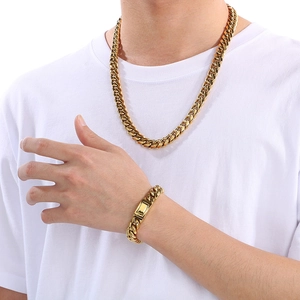 Close-up of 12mm golden Cuban link necklace and bracelet set on a white t-shirt