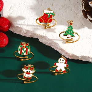 Christmas theme open rings set with reindeer and tree charms on white stone surface