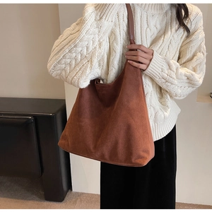 Detail of soft brown suede tote bag featuring a large capacity and matte vintage texture
