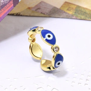 Macro shot of gold adjustable ring with blue evil eye motifs and sparkling zircon accents