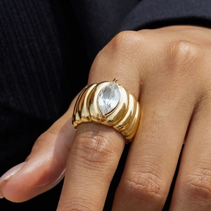Lussuoso anello a coste dorato con un grande cristallo marquise sulla mano di un modello
