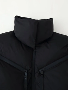 Detail of the stand collar and zipper pockets on this matte black padded jacket