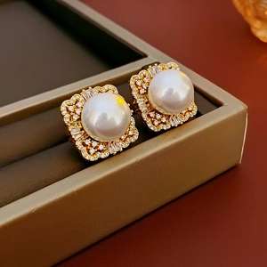 Macro shot of vintage pearl earrings with gold metal and zircon inlay in a jewelry box