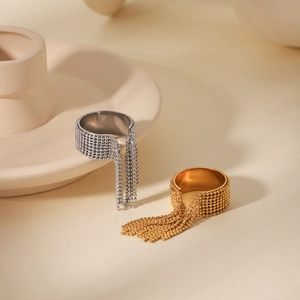 Dettaglio ravvicinato di anelli con nappe di perline color oro e argento su ceramica